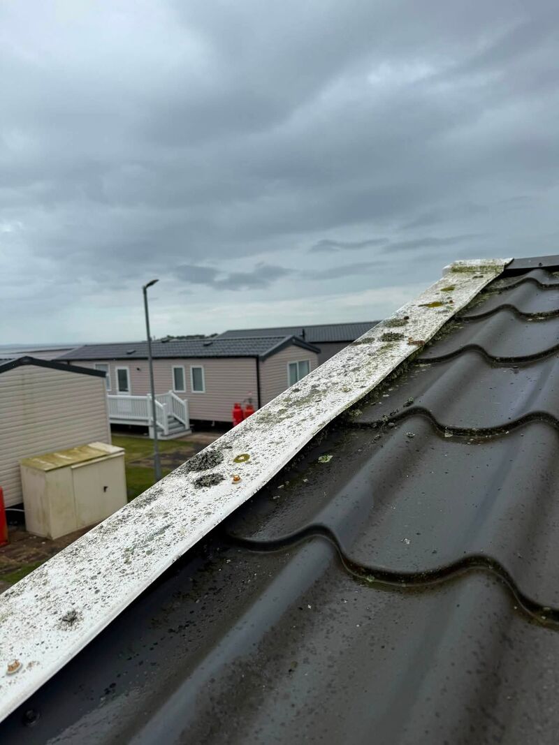 Static caravan roof ridge spotted with lichen before cleaning