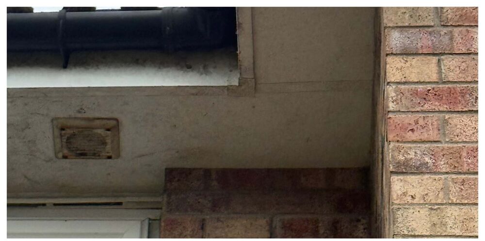 Discoloured soffit and dirty vent before washing